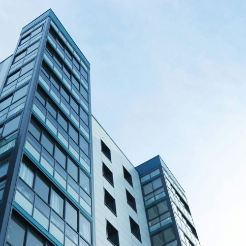 Low-angle view of a modern glass skyscraper against a clear sky in Poole, UK.